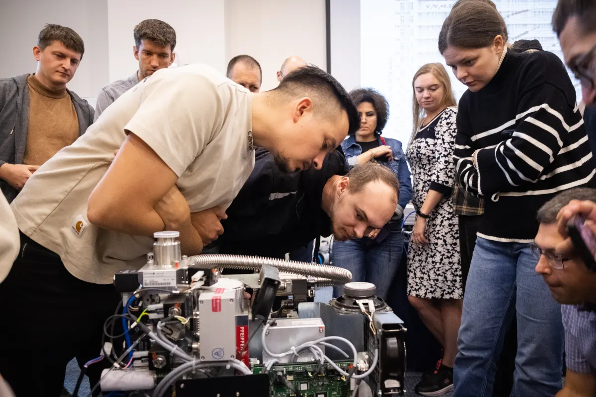 Course participants working hands-on with a helium leak detector during VacMentor training