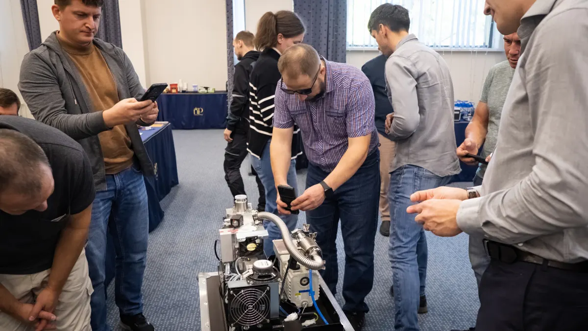 Course participants working hands-on with a helium leak detector during VacMentor training