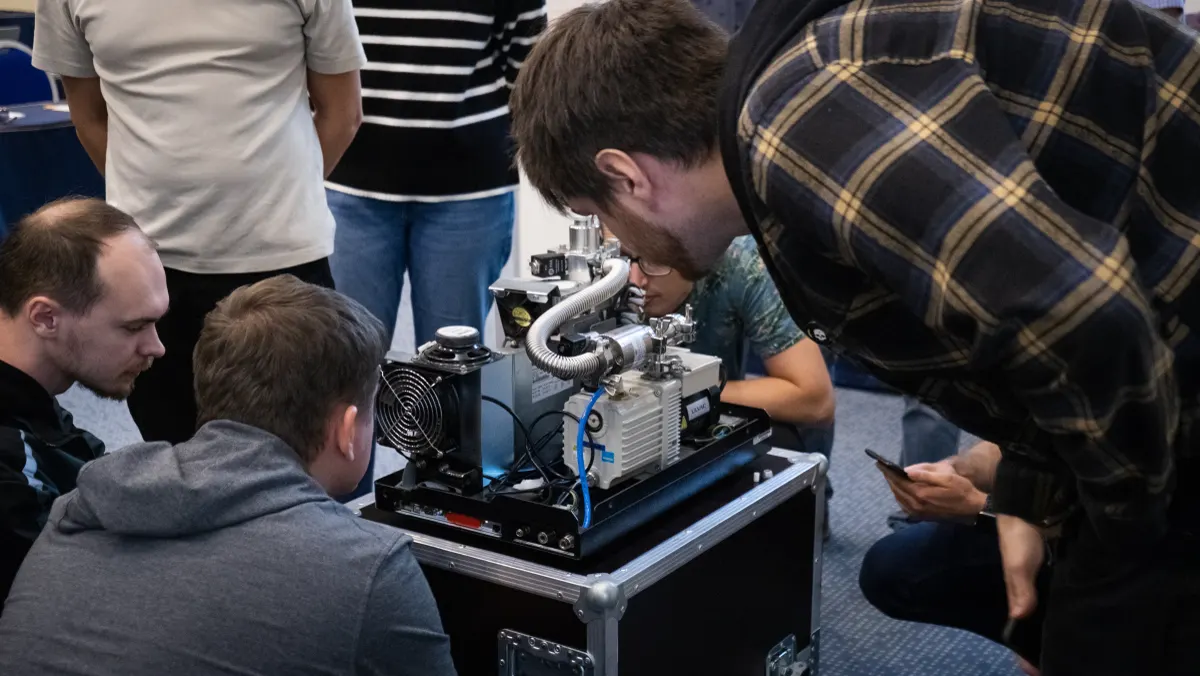 Course participants working hands-on with a helium leak detector during VacMentor training