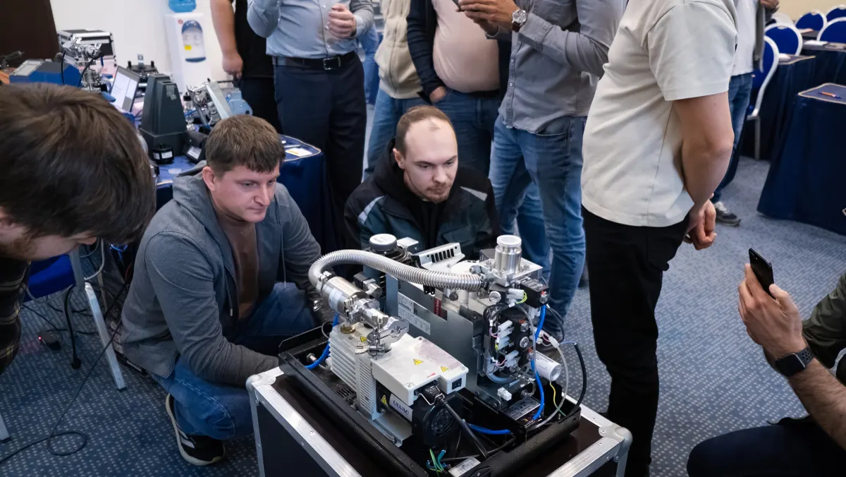 Course participants working hands-on with a helium leak detector during VacMentor training