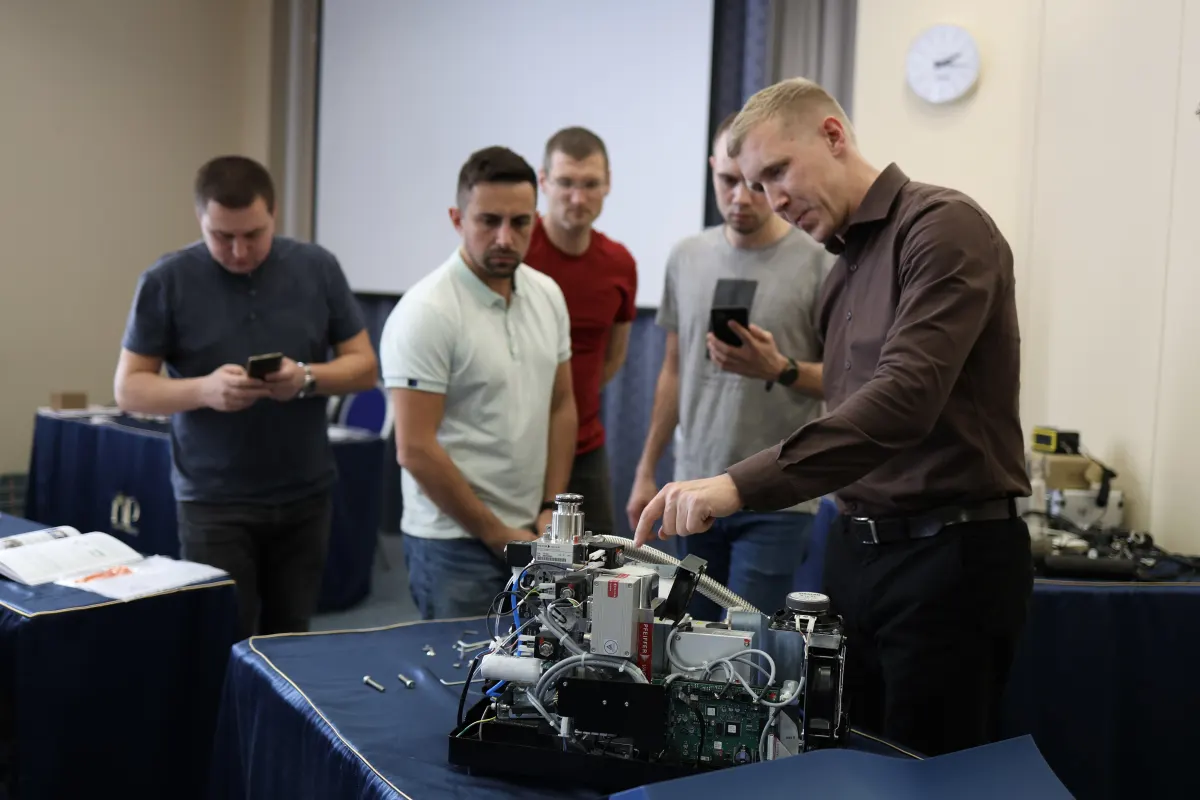 Course participants working hands-on with a helium leak detector during VacMentor training