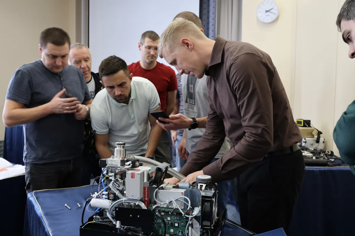 Course participants working hands-on with a helium leak detector during VacMentor training
