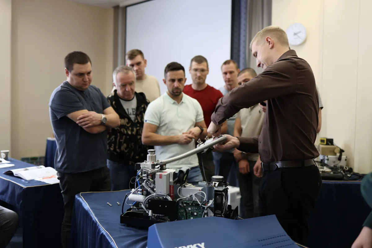Course participants working hands-on with a helium leak detector during VacMentor training