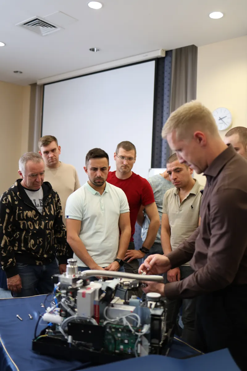 Course participants working hands-on with a helium leak detector during VacMentor training