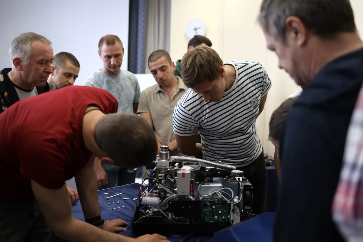 Course participants working hands-on with a helium leak detector during VacMentor training