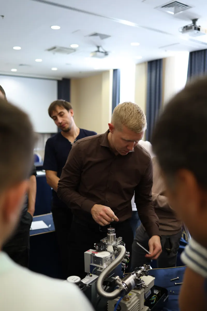 Course participants working hands-on with a helium leak detector during VacMentor training