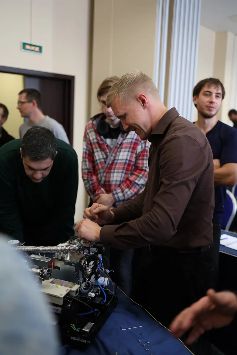 Course participants working hands-on with a helium leak detector during VacMentor training