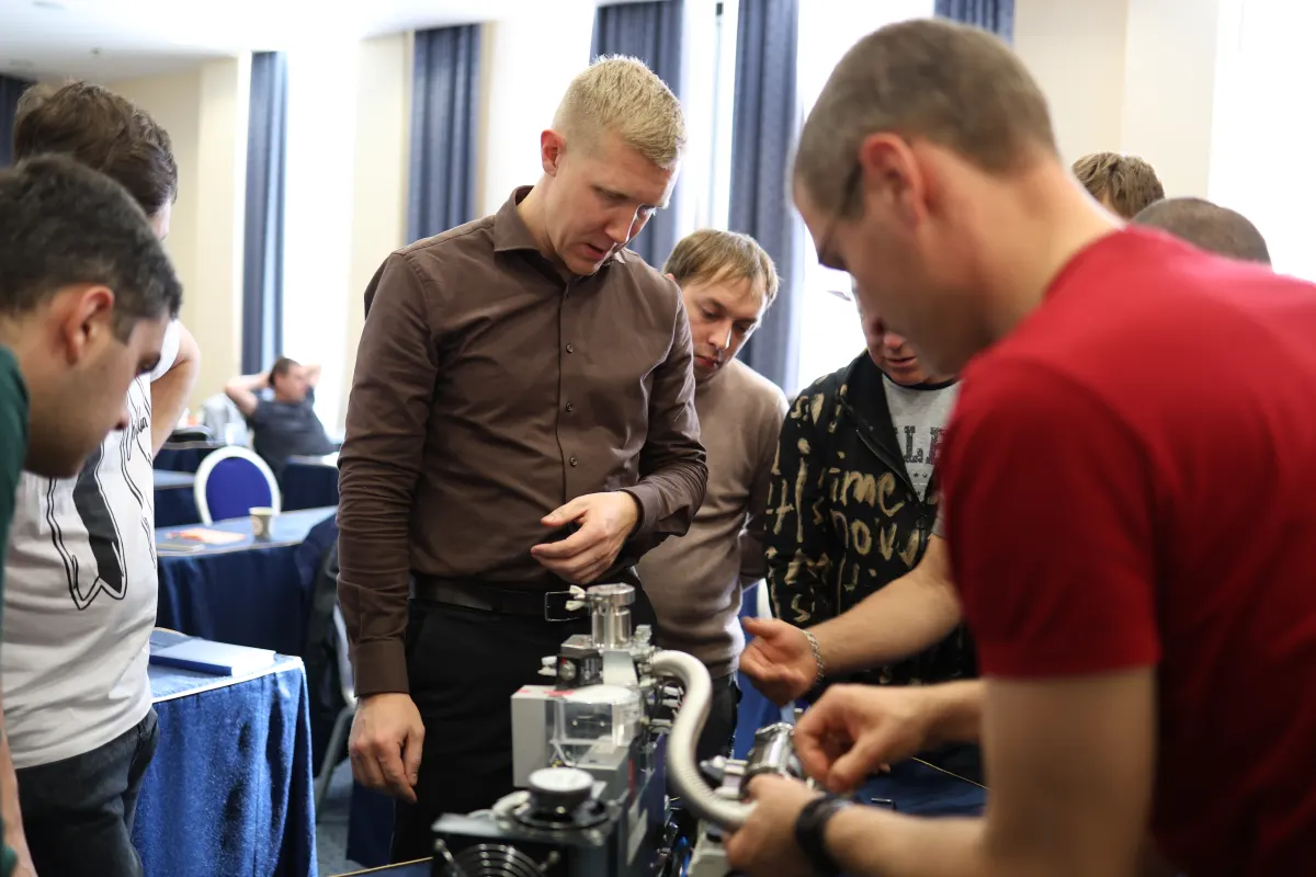 Course participants working hands-on with a helium leak detector during VacMentor training