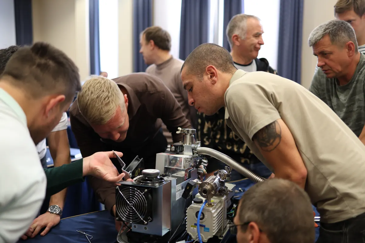 Course participants working hands-on with a helium leak detector during VacMentor training
