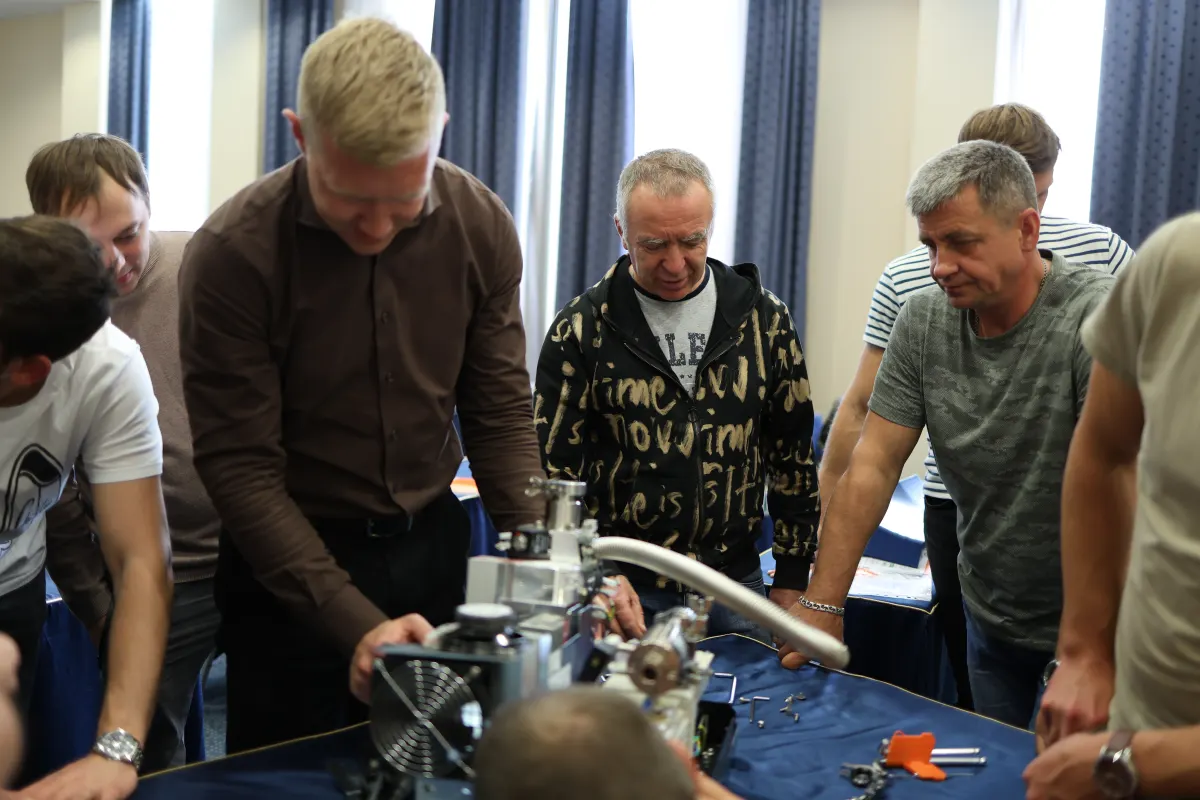 Course participants working hands-on with a helium leak detector during VacMentor training