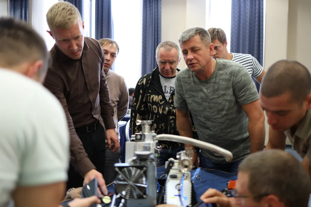 Course participants working hands-on with a helium leak detector during VacMentor training