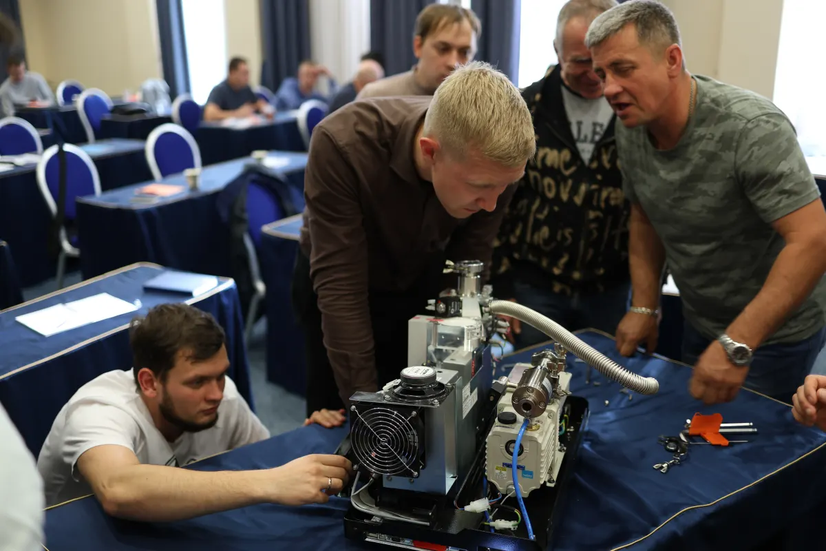 Course participants working hands-on with a helium leak detector during VacMentor training