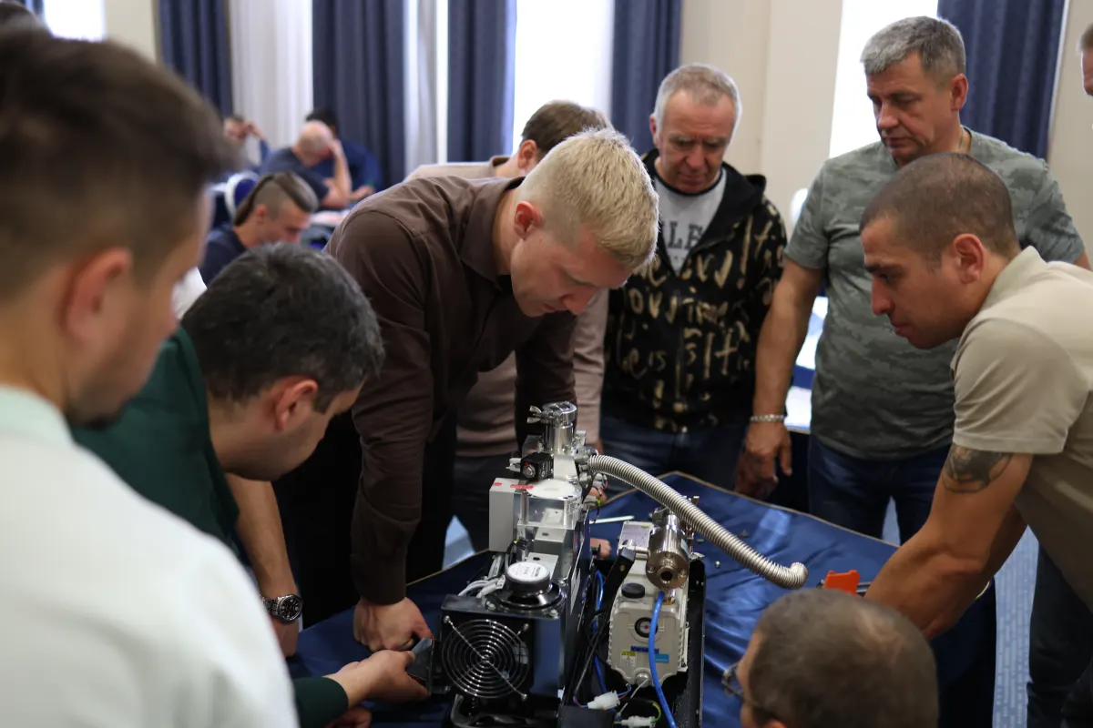Course participants working hands-on with a helium leak detector during VacMentor training