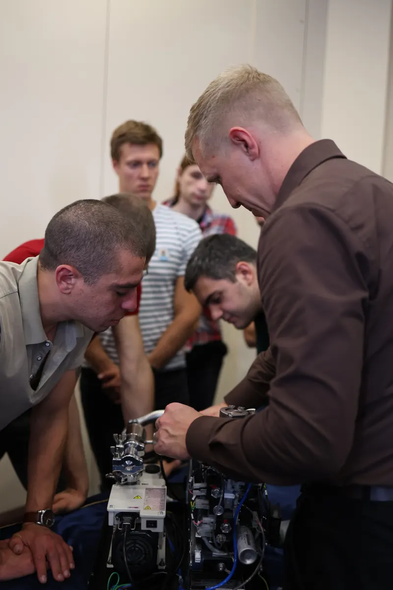 Course participants working hands-on with a helium leak detector during VacMentor training