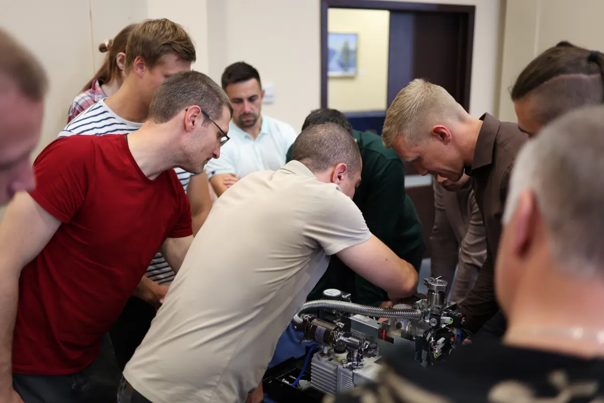 Course participants working hands-on with a helium leak detector during VacMentor training