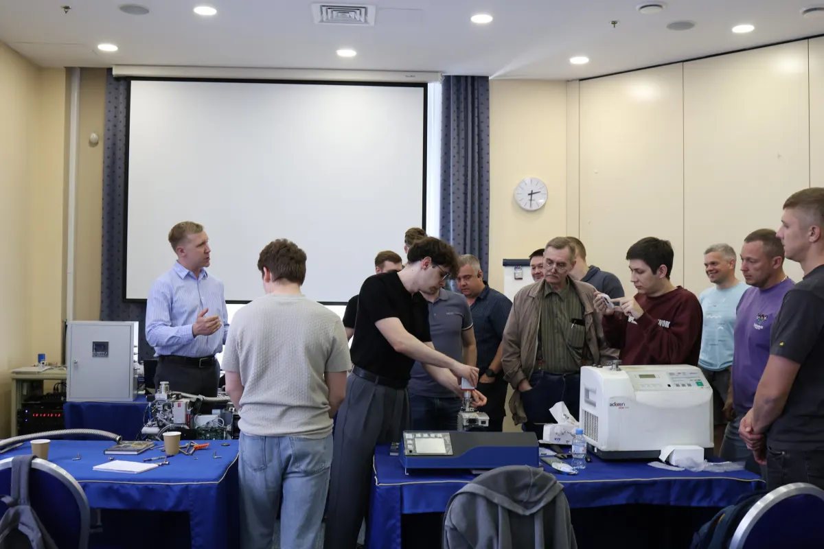 Course participants working hands-on with a helium leak detector during VacMentor training