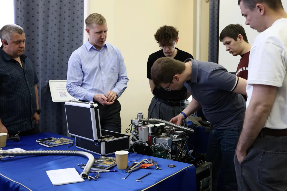 Course participants working hands-on with a helium leak detector during VacMentor training