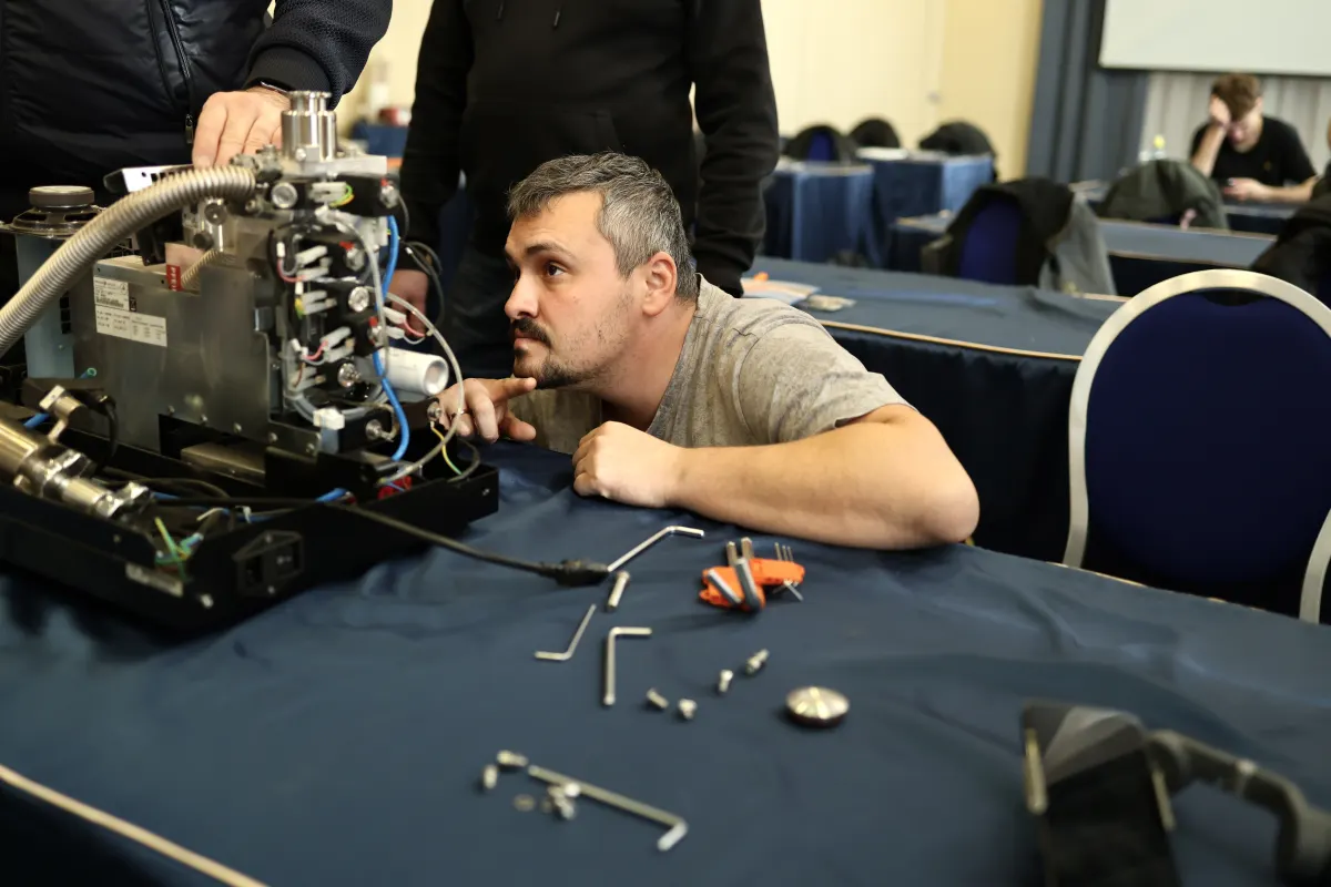 Course participants working hands-on with a helium leak detector during VacMentor training