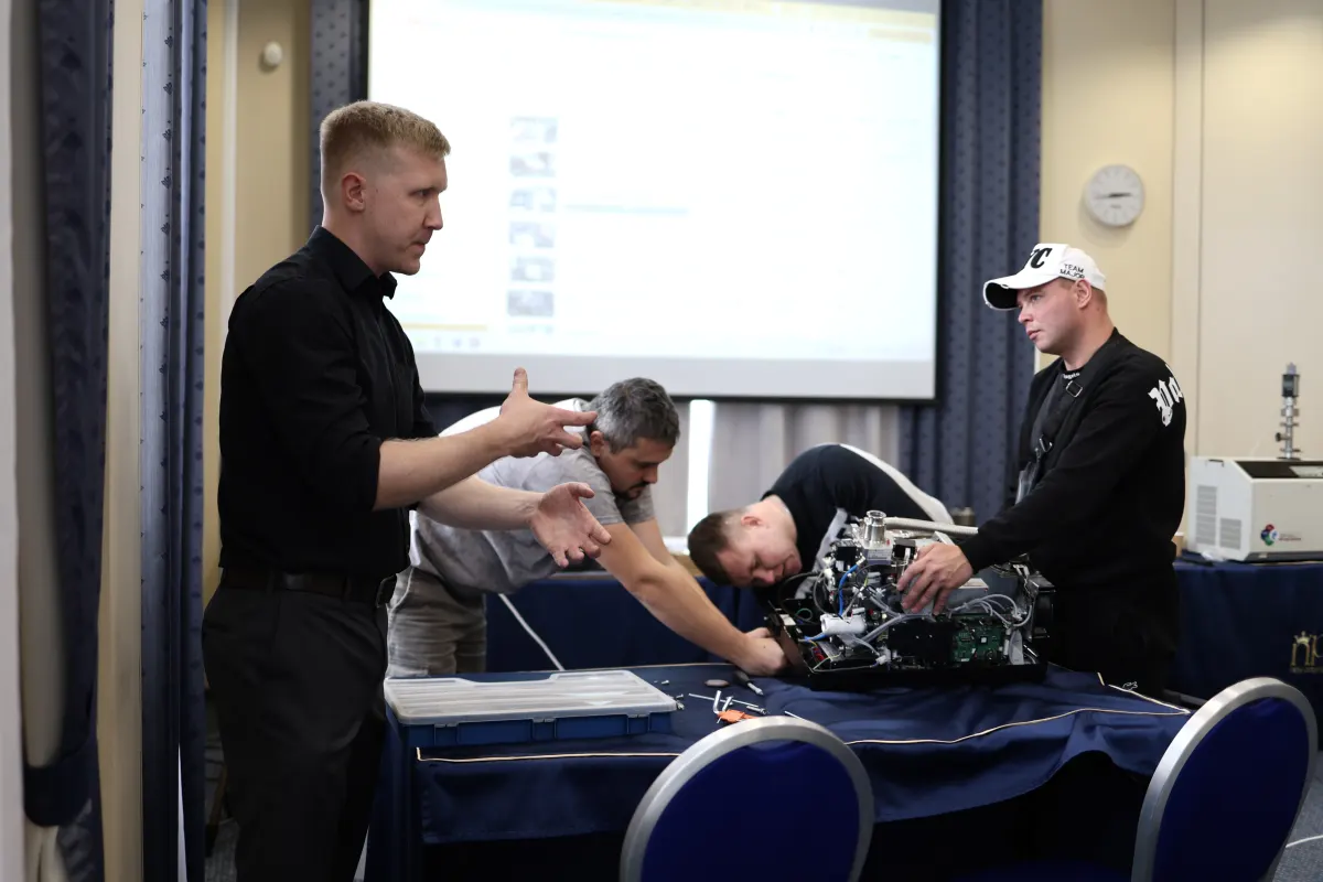 Course participants working hands-on with a helium leak detector during VacMentor training