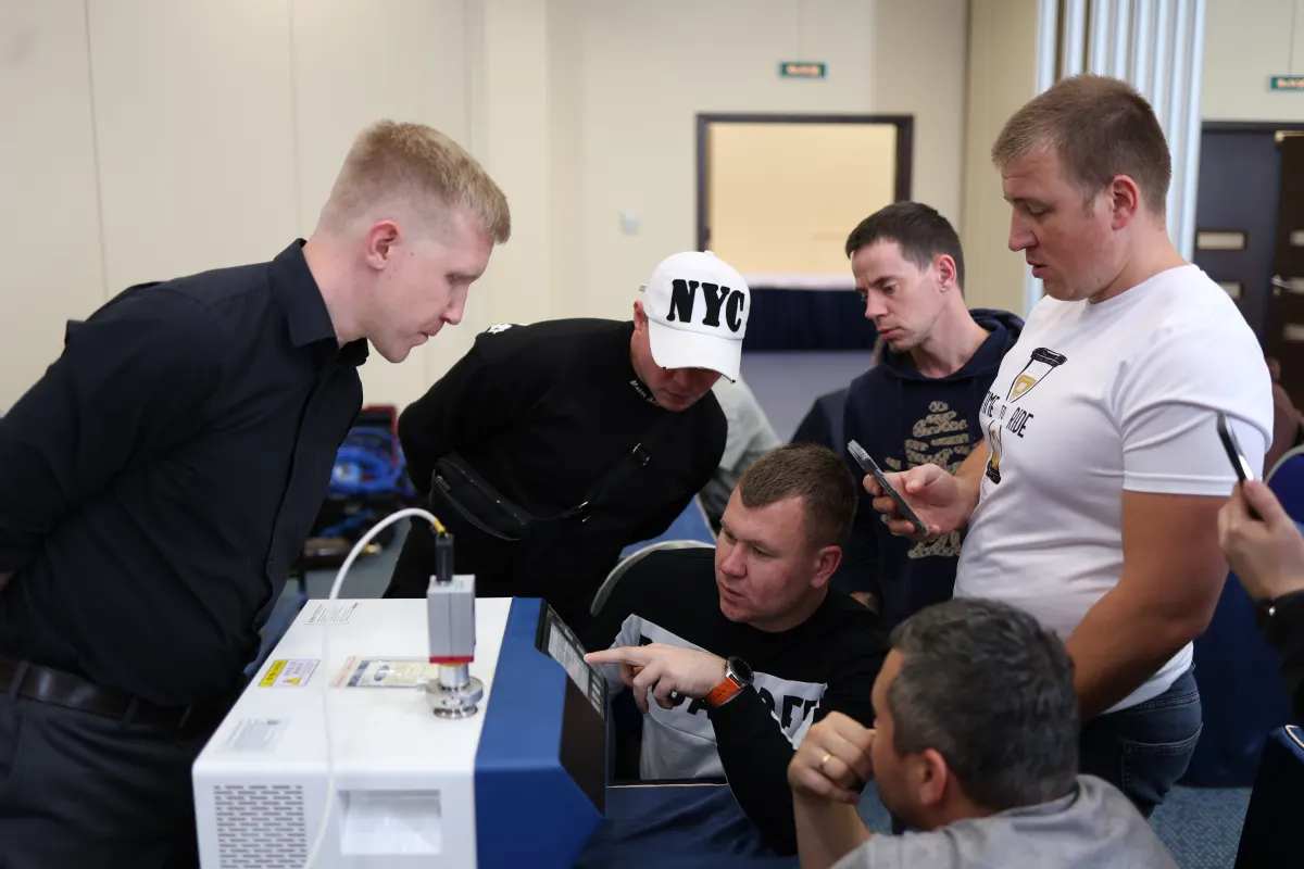 Course participants working hands-on with a helium leak detector during VacMentor training